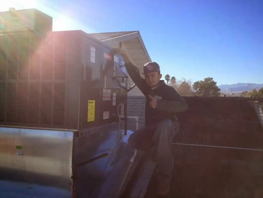 HVAC technician performing HVAC Inspection on a rooftop unit in Oakton